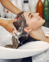 Profesional lavando y peinando el cabello en el domicilio del cliente
