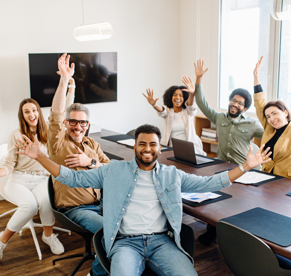 A,Vibrant,Office,Team,Celebrates,With,Raised,Hands,And,Beaming